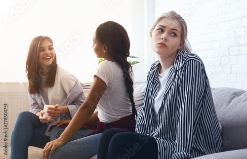 Sad girl sitting alone, avoid talking to classmates photo