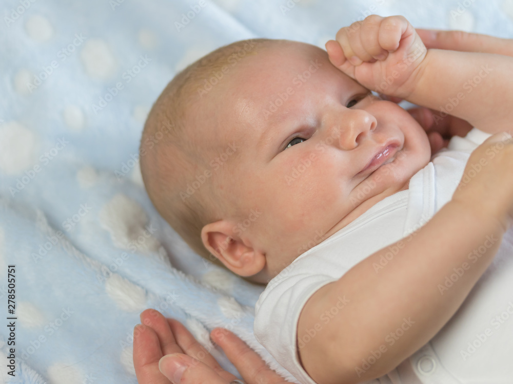 Portrait of frowning newborn boy lying on blanket Portrait of frowning newborn boy lying on blanket