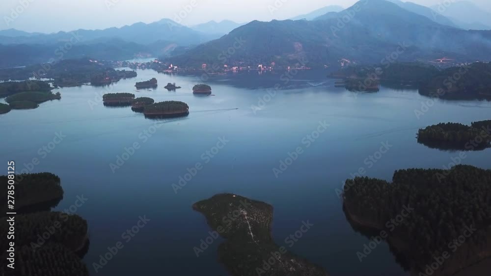 Thac Ba Lake, Vu Linh, Vietnam, aerial view of the lake with calm water and traditional Vietnamese boats, small islands and village on the lake shore, aerial drone ascending establishing shot Thac Ba Lake, Vu Linh, Vietnam, aerial view of the lake with calm water and traditional Vietnamese boats, small islands and village on the lake shore, aerial drone ascending establishing shot