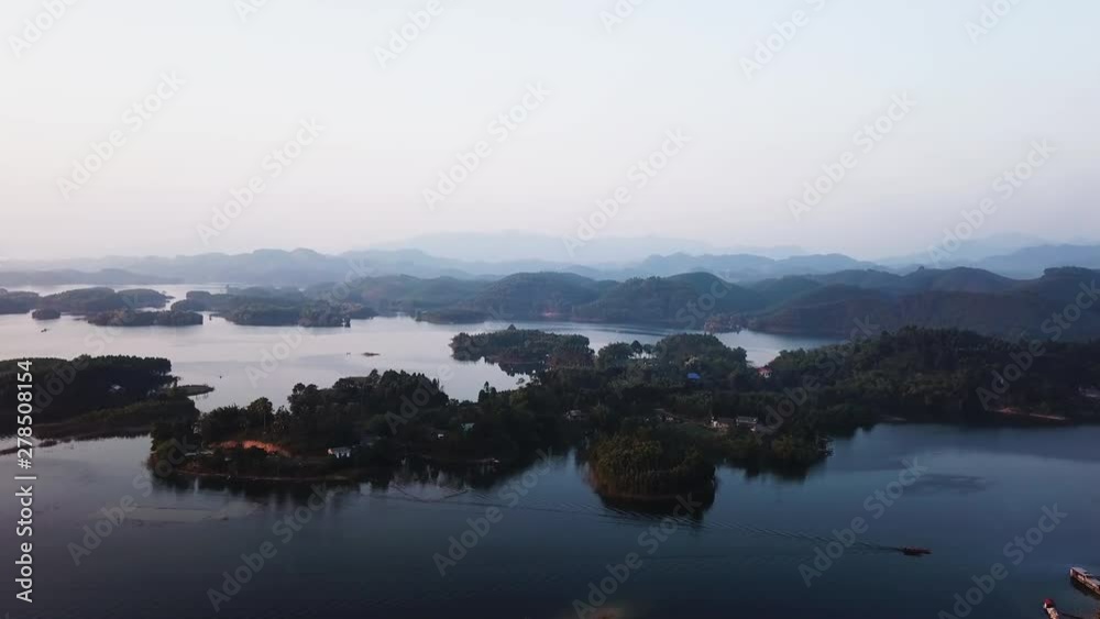 preserved nature and biodiversity of the Thac Ba Lake, Vu Linh, Vietnam. Aerial drone orbiting shot above calm water and small islands with tropical vegetation preserved nature and biodiversity of the Thac Ba Lake, Vu Linh, Vietnam. Aerial drone orbiting shot above calm water and small islands with tropical vegetation