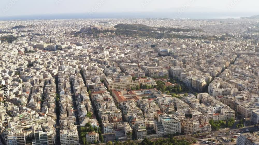 Aerial view of a slide with drone on the panorama of buildings of residential and administrative houses city Athens, the capital of Greece at sunrise. The lights of a sun. Bird's-eye view of rooftops Aerial view of a slide with drone on the panorama of buildings of residential and administrative houses city Athens, the capital of Greece at sunrise. The lights of a sun. Bird's-eye view of rooftops