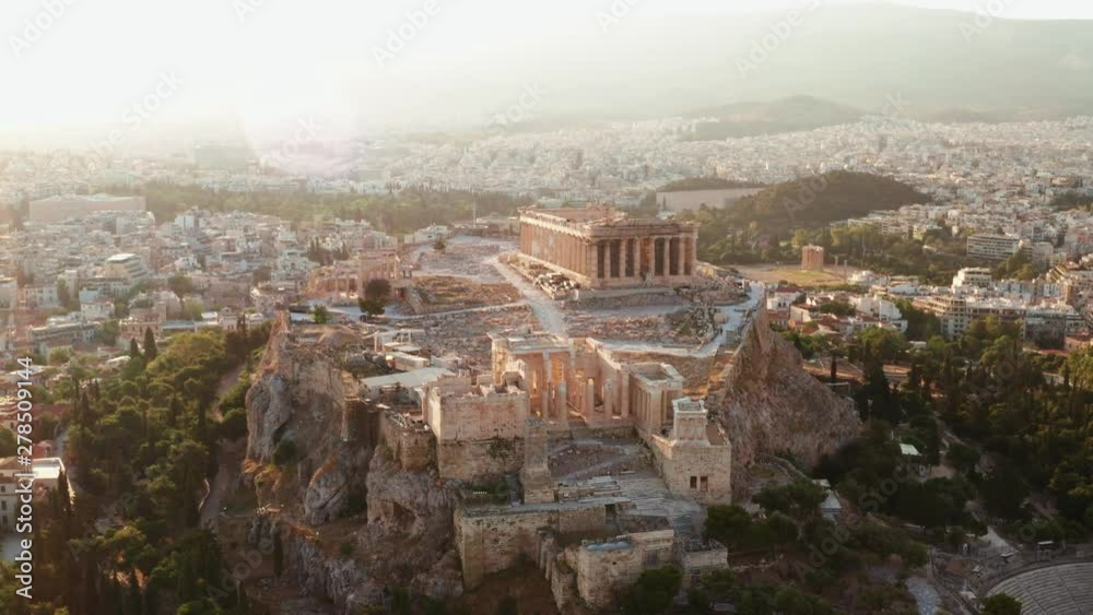 Aerial view of a slide from the drone on the panorama of residential buildings of the city of Athens, on the main symbol of ancient Greece, Acropolis at sunrise. The lights sun. World Heritage sites Aerial view of a slide from the drone on the panorama of residential buildings of the city of Athens, on the main symbol of ancient Greece, Acropolis at sunrise. The lights sun. World Heritage sites