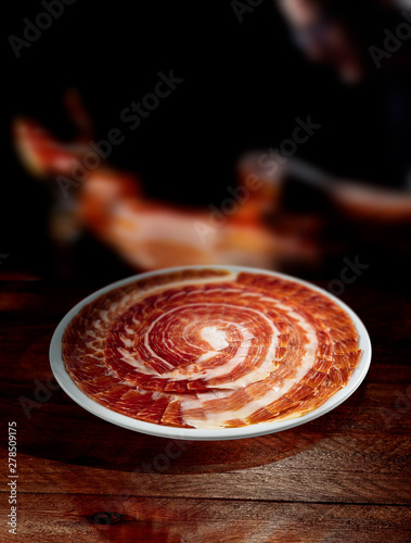 jamón iberico cortado en plato sobre fondo de madera.  Iberian ham cut photo
