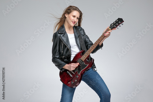 Positive guitarist girl playing and smiling