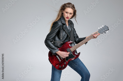 Thoughtful young women playing electric guitar