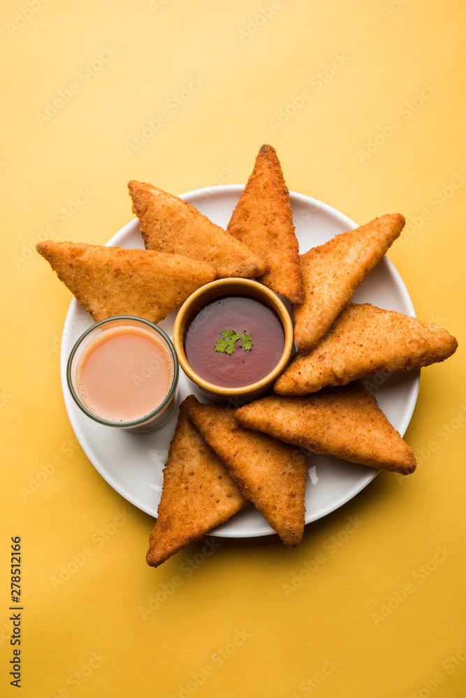 crispy Potato triangles or batata vada covered with bread crumbs and then deep fried. served with tomato ketchup. selective focus crispy Potato triangles or batata vada covered with bread crumbs and then deep fried. served with tomato ketchup. selective focus