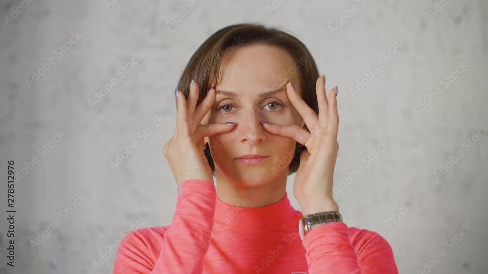 Young caucasian woman in red rose turtleneck make faces infront of camera close up. Joking. Face gimnastics relax eyes Young caucasian woman in red rose turtleneck make faces infront of camera close up. Joking. Face gimnastics relax eyes