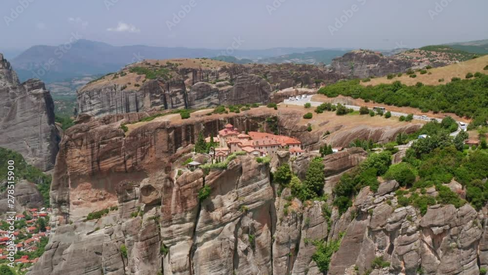 Aerial view of slide turn drone on panorama of mountain range and roofs of residential buildings. Kalambaka city, Greece. Tops of the rocks of Meteora. Orthodox monasteries Meteora. Travel, tourism Aerial view of slide turn drone on panorama of mountain range and roofs of residential buildings. Kalambaka city, Greece. Tops of the rocks of Meteora. Orthodox monasteries Meteora. Travel, tourism