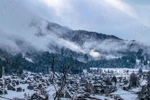 clouds descending a mountain in a snowed landscape