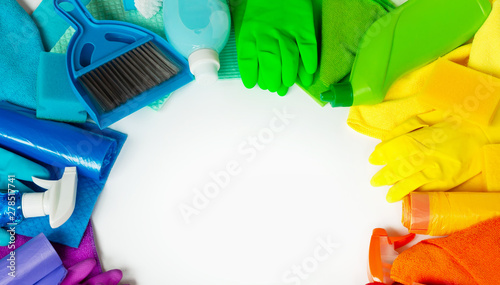 Rainbow set for cleaning the house on a white background, laid out in a circle. Place for text.