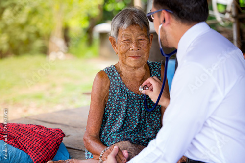 Fotografie The doctor checks the health of the elderly in the rural of asian