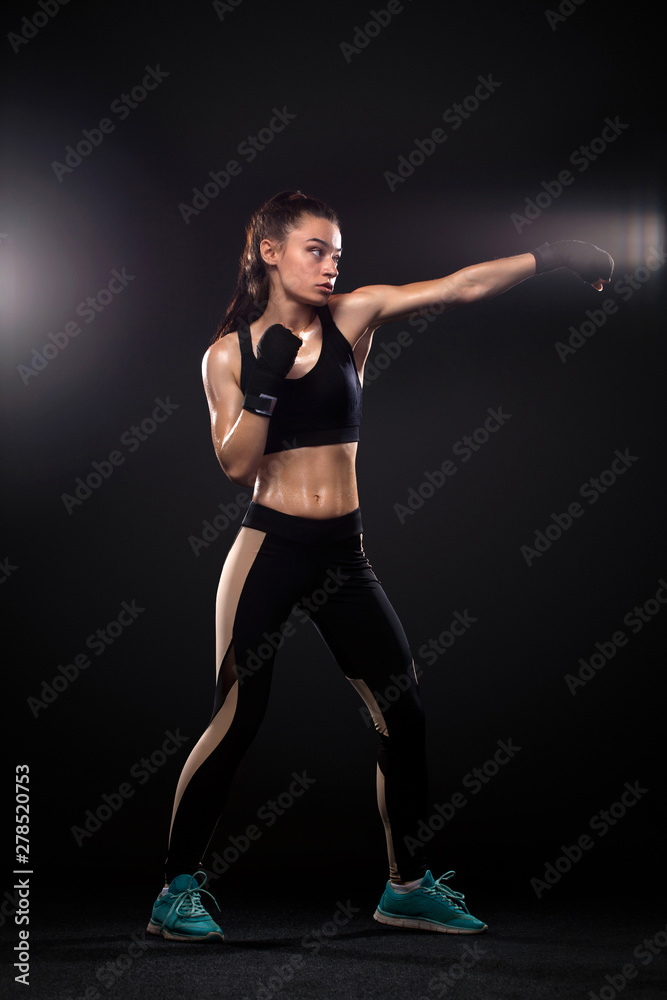 Sportsman, woman boxer fighting in gloves on black background. Boxing and fitness concept.