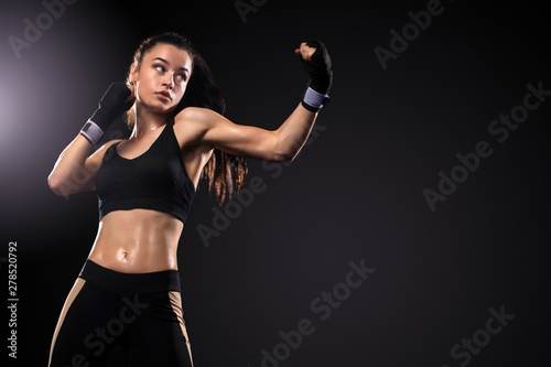 Sportsman, woman boxer fighting in gloves on black background. Boxing and fitness concept.