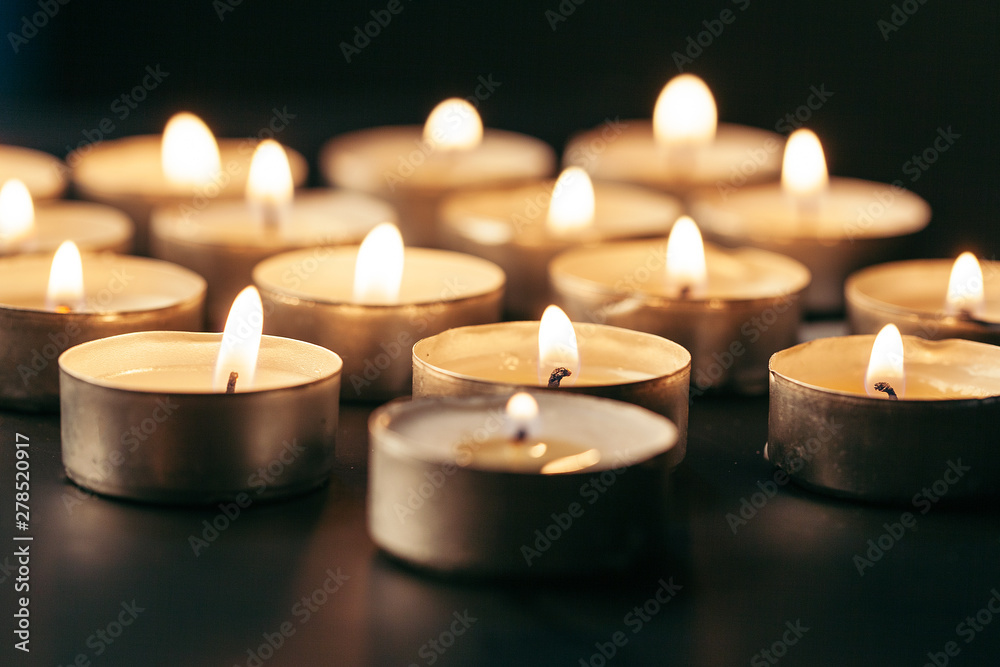 Burning candle on table in darkness, space for text. Funeral symbol Burning candle on table in darkness, space for text. Funeral symbol