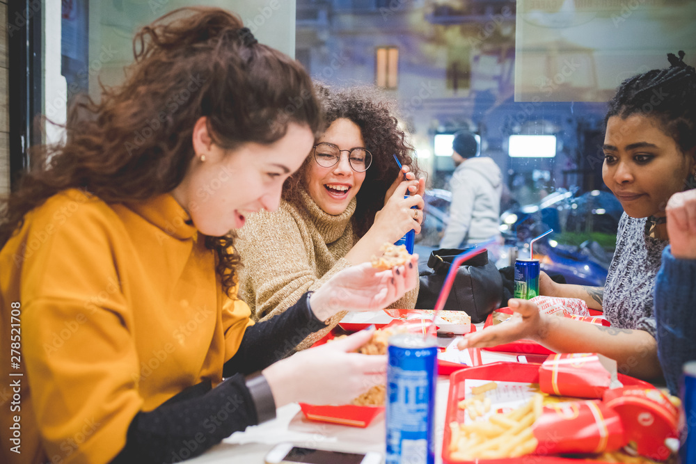 group of girlfriends eating diner in fast food group of girlfriends eating diner in fast food