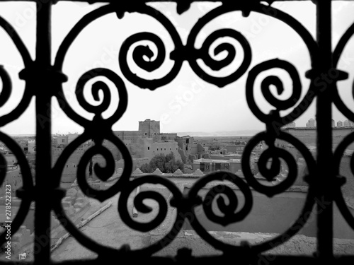 View of a city through ornate window bars 