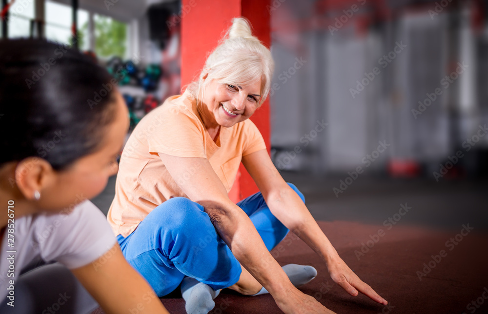 Senior woman workout with trainer at the gym Senior woman workout with trainer at the gym