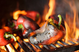 Close-up of fresh organic red paprika being grilled on open flame. Preparing traditional Balkan's delicacy Ajvar spread
