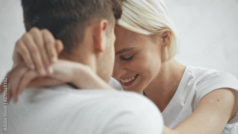 beautiful young couple embracing, smiling and kissing at home beautiful young couple embracing, smiling and kissing at home