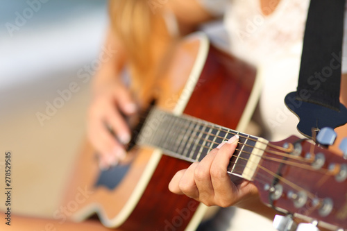 Closeup of a girl on the beach playing classic guitar photo