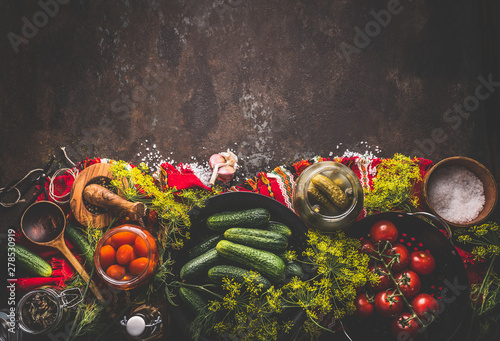 Foto Food background with cucumber and tomatoes pickling , canning and preserving ingredients on dark rustic background, top view