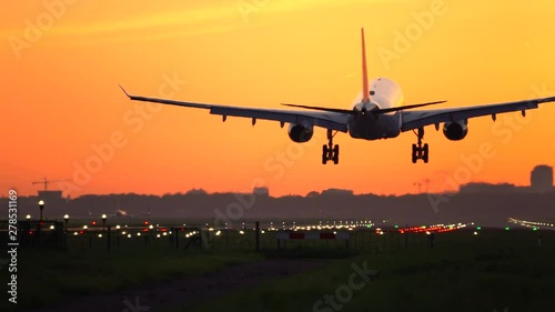 Airplane landing with orange sky