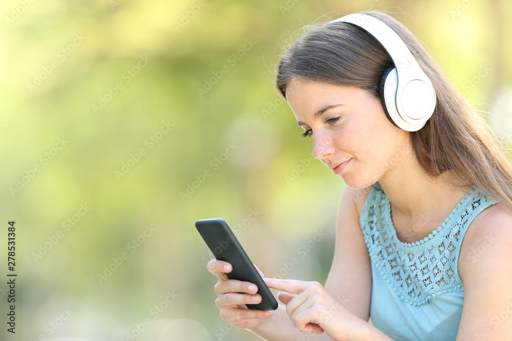 Serious woman listening to music using smart phone