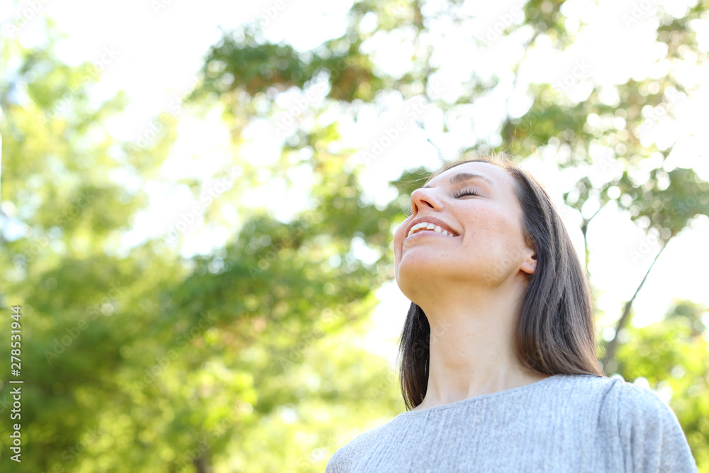 Happy adult woman breathing fresh air in a forest Happy adult woman breathing fresh air in a forest