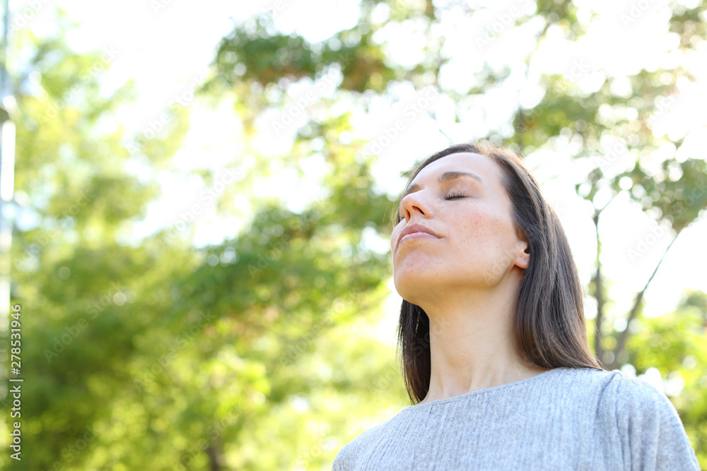 Relaxed adult woman breathing fresh air in a forest Relaxed adult woman breathing fresh air in a forest