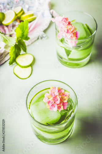 Glass of green iced cucumber rosemary drink. refreshing drink with ice. Infused water . Healthy summer beverages . Homemade lemonade with fresh herbs