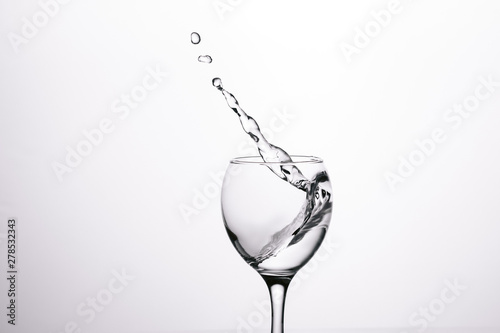 splash of water in wineglass isolated on white background.