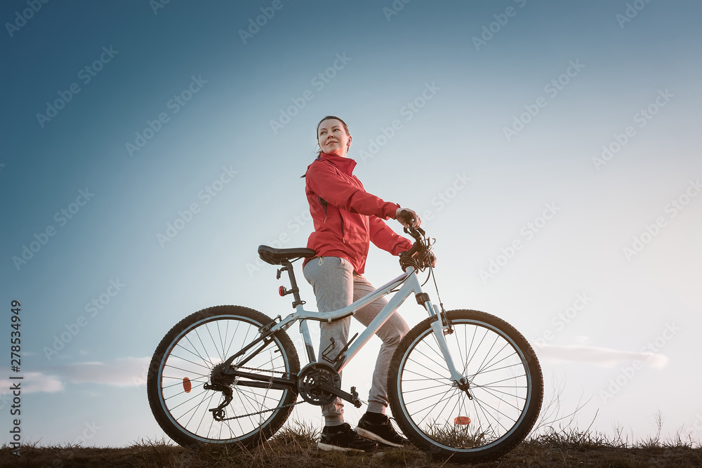 young woman with mountain bike at the sunset. young woman with mountain bike at the sunset.
