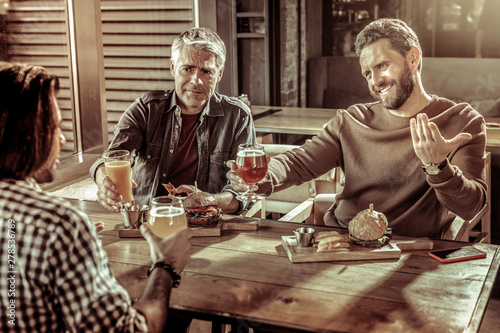 Handsome bearded male person talking to his friend