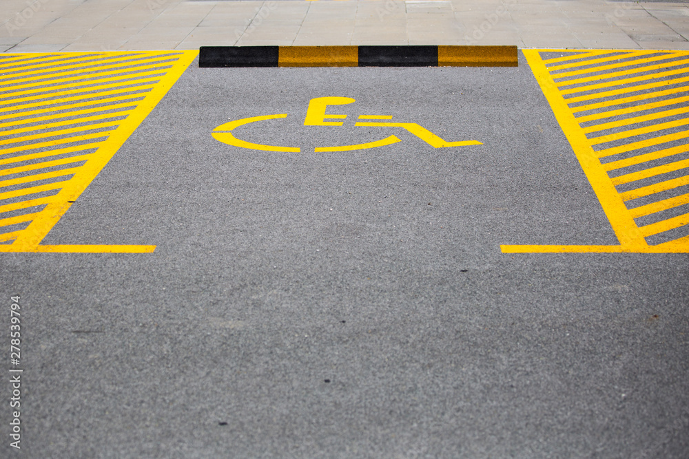 Handicapped parking spot. Parking place reserved for disabled people. Handicap symbol on road Handicapped parking spot. Parking place reserved for disabled people. Handicap symbol on road