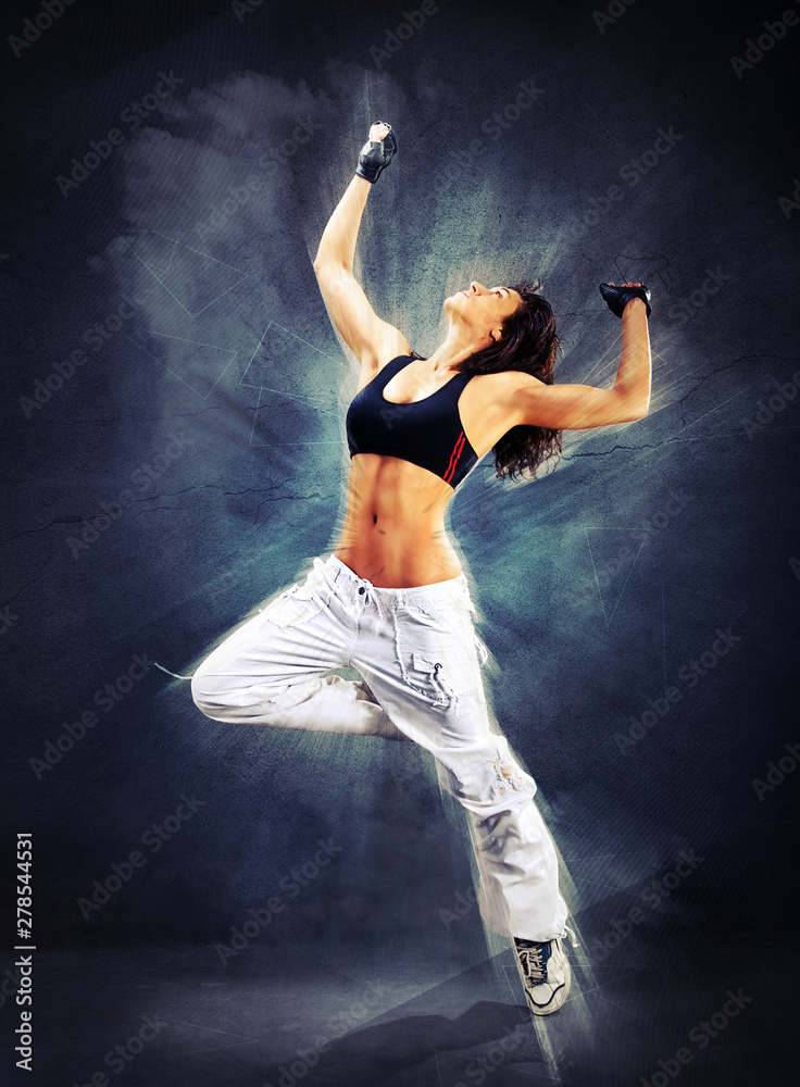 Young beautiful athletic woman jumping dancing modern style dance hip-hop on studio on wall background 