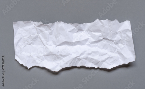 Modern crumpled white paper on empty sheet gray background with light shadows for creative wallpaper, card, art work design.