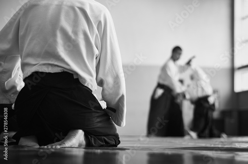 Aikido training. Black and white image. The teacher shows reception.  Traditional form of clothing in Aikido. photo