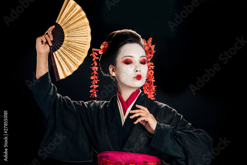 Valokuva geisha in black kimono with red flowers in hair dancing with traditional asian h