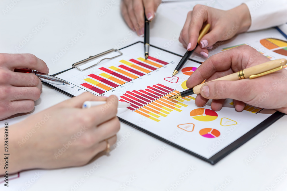 Close up on hands with pen pointing at business graph Close up on hands with pen pointing at business graph