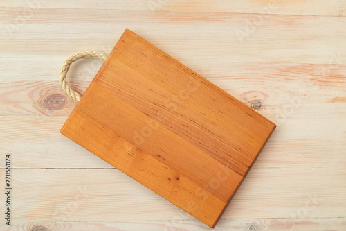 Food background. Top view of empty wooden cutting board on wooden planks vintage table with copy space.