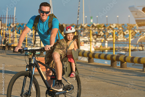 father and daughter on a bike. bicycle childseat. photo