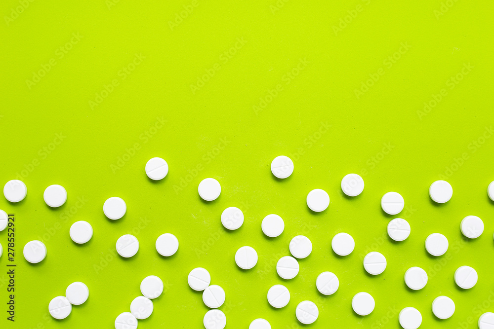 Tablets of Paracetamol on green background.