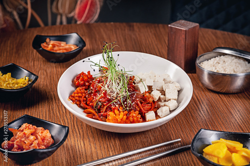 Flat lay korean traditional food with kimchi on wooden background. Korean noodles with onions, red sauce and sesame, chicken meat. Traditional asian cuisine. Lunch. Healthy food