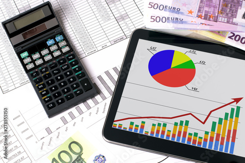 Workplace with tablet and stock charts. Accountant work table