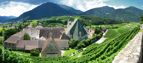 Beautiful view of Novacella Monastery surrounded by green vineyards in summer, south tyrol. Bressanone (BZ) Italy.