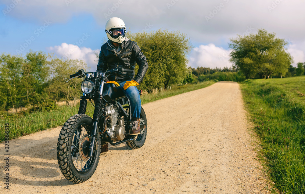 Young man with helmet riding a custom motorbike outdoors
