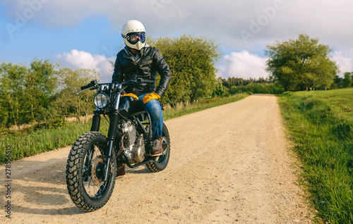 Fototapeta Naklejka Na Ścianę i Meble -  Young man with helmet riding a custom motorbike outdoors