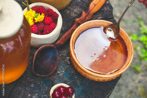 raspberry and honey in a beautiful dish on a wooden table