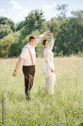 Newlywed couple dancing in the meadow