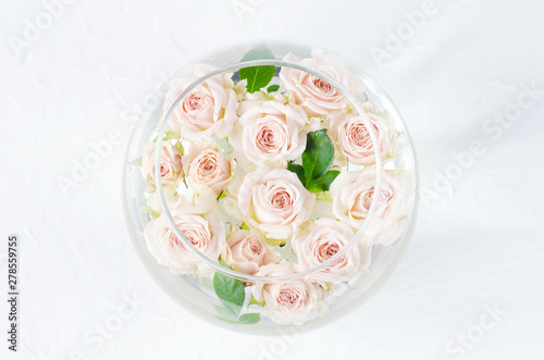 Round vessel with water and small peach roses.